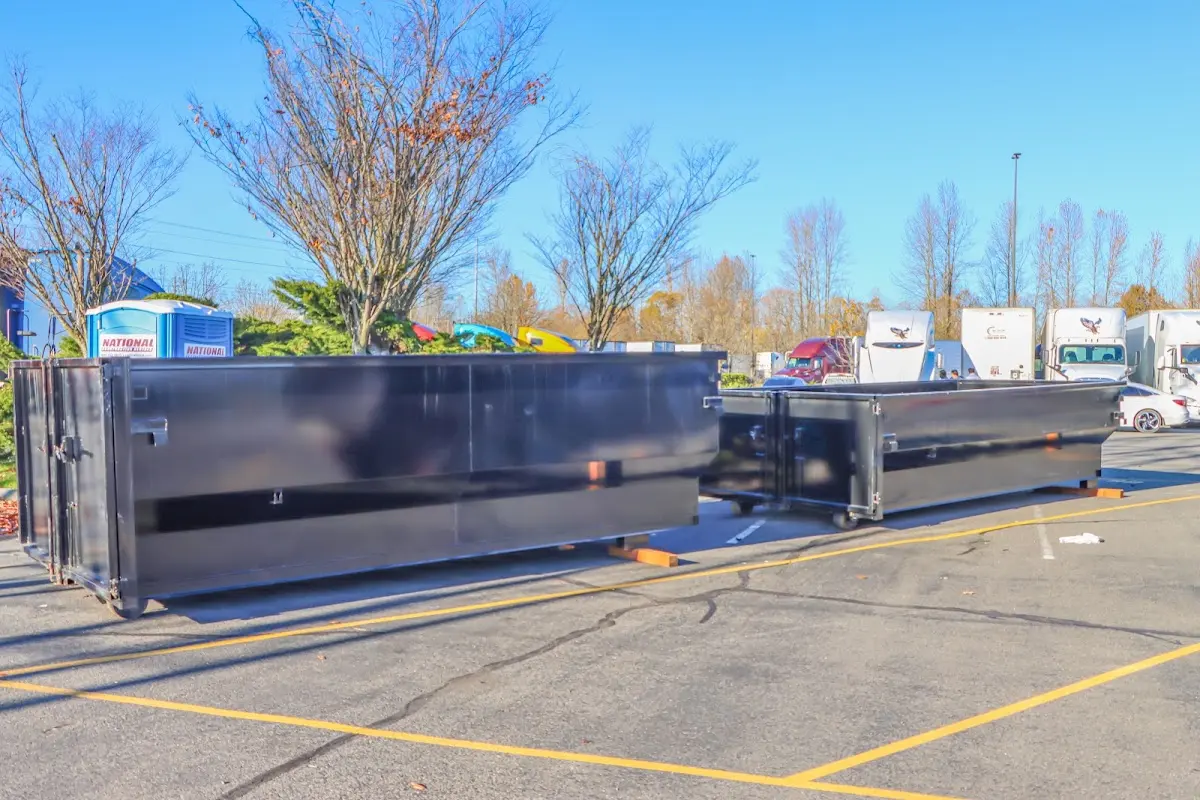 Professional dumpster rental service with roll-off container on residential driveway in Battlement Mesa